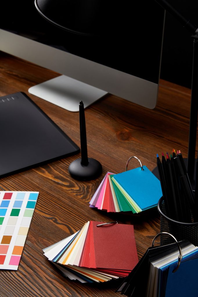 close up view of graphic designer workplace with colorful pallet, graphic tablet and computer screen